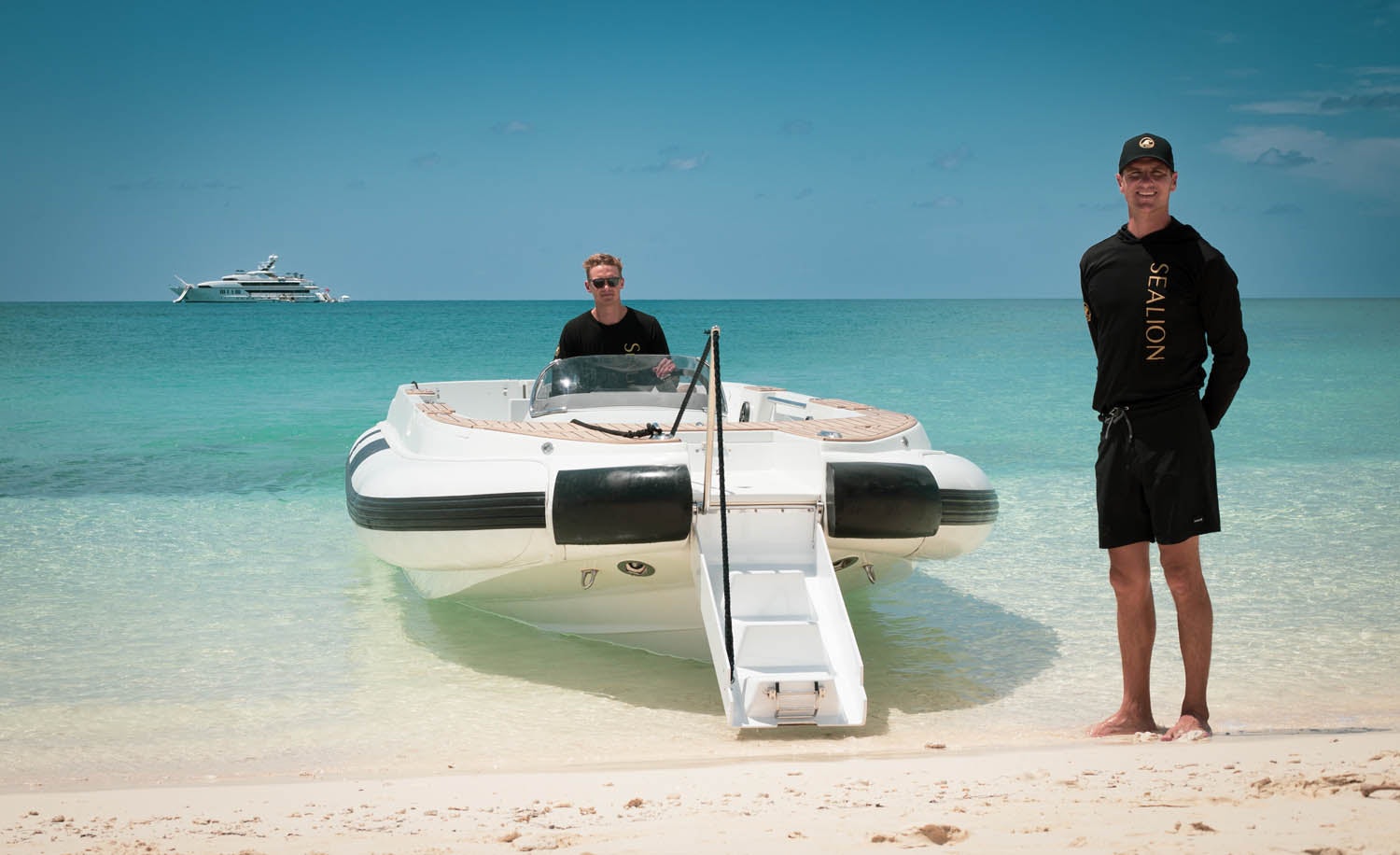 a man and a woman standing next to a boat on a beach aboard SEALION Yacht for Charter
