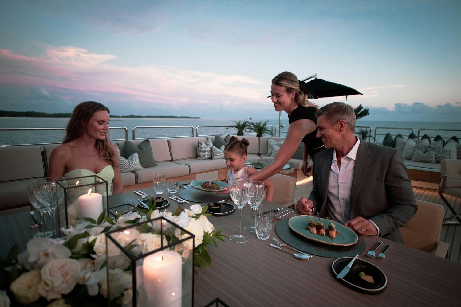 a group of people sitting at a table with food and drinks on it aboard SEALION Yacht for Charter
