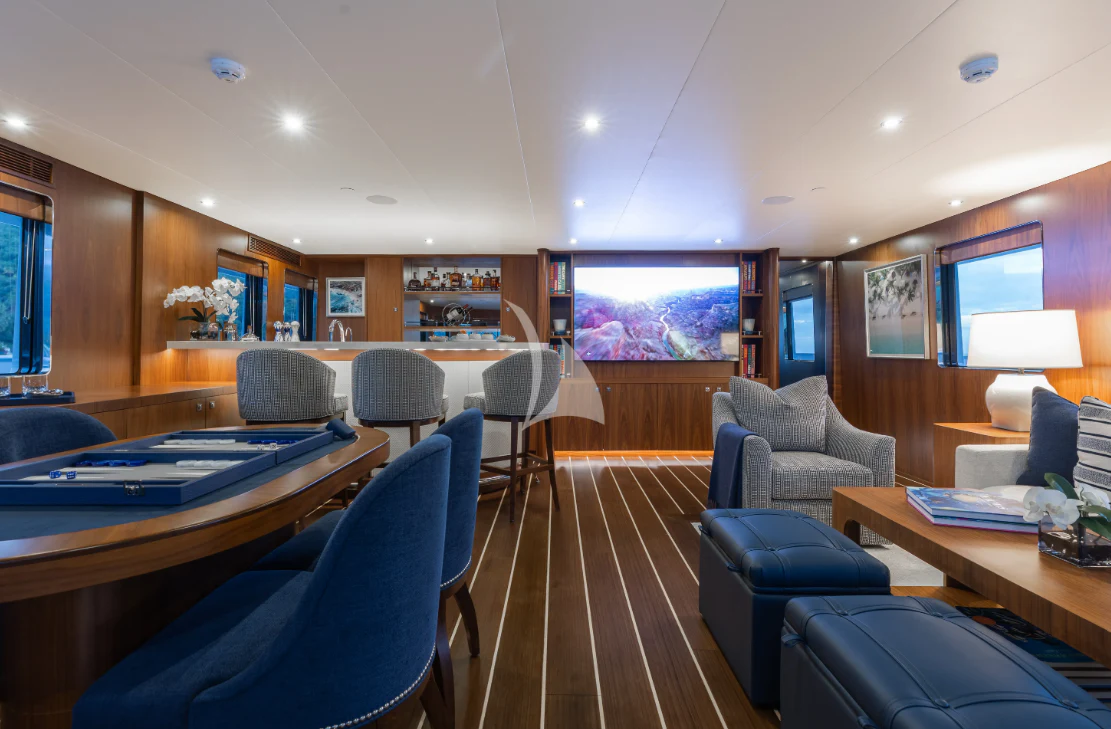 a room with a table chairs and a pool table aboard LIMITED RISKS Yacht for Charter