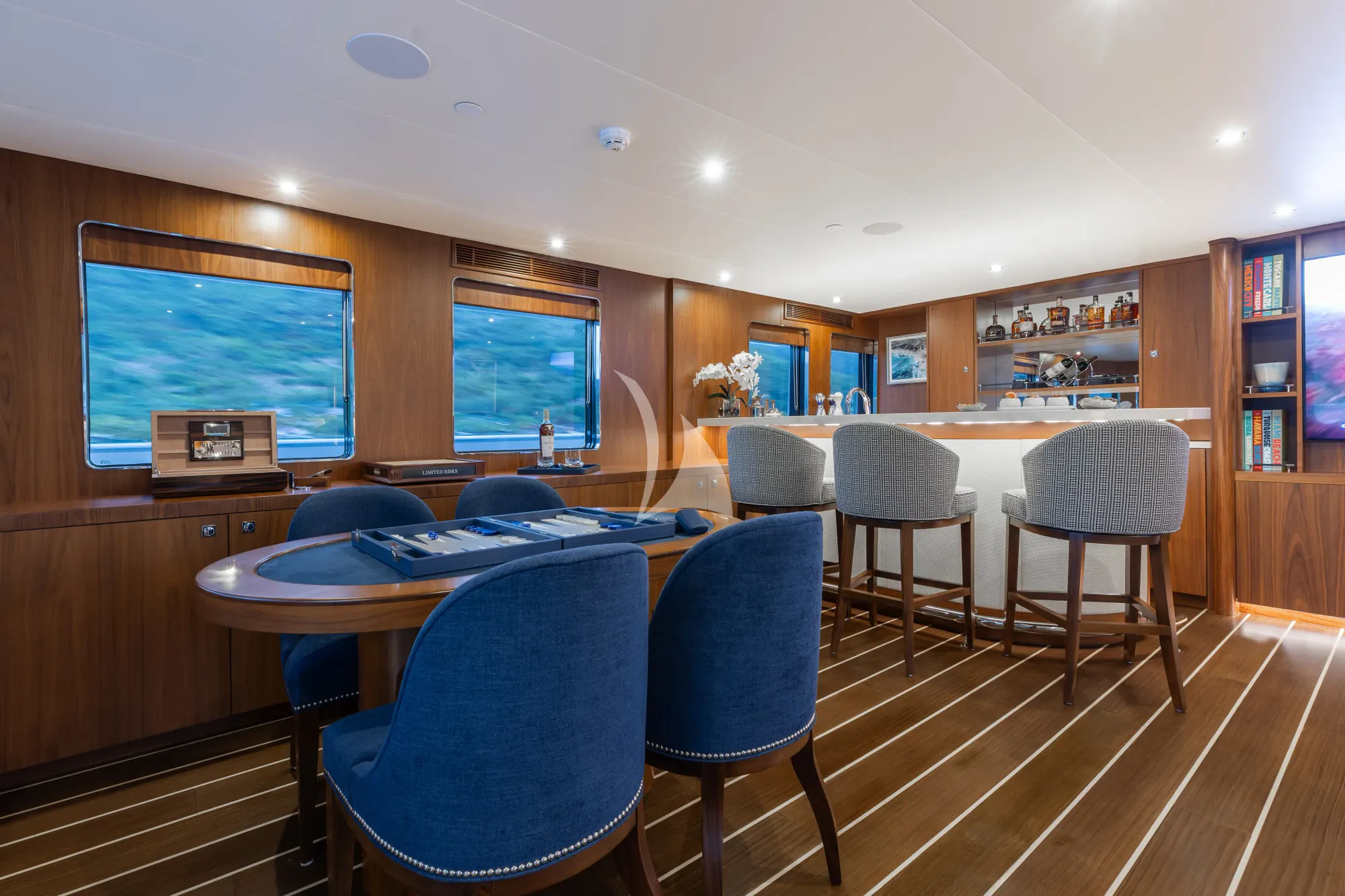 a room with a table chairs and a book shelf aboard LIMITED RISKS Yacht for Charter