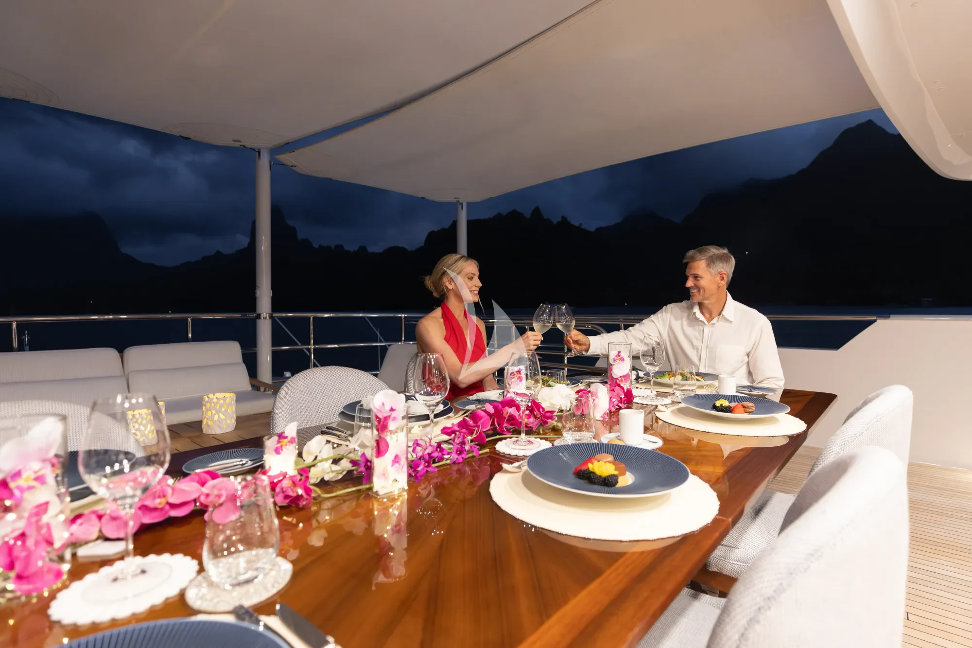 a couple sitting at a table aboard LIMITED RISKS Yacht for Charter