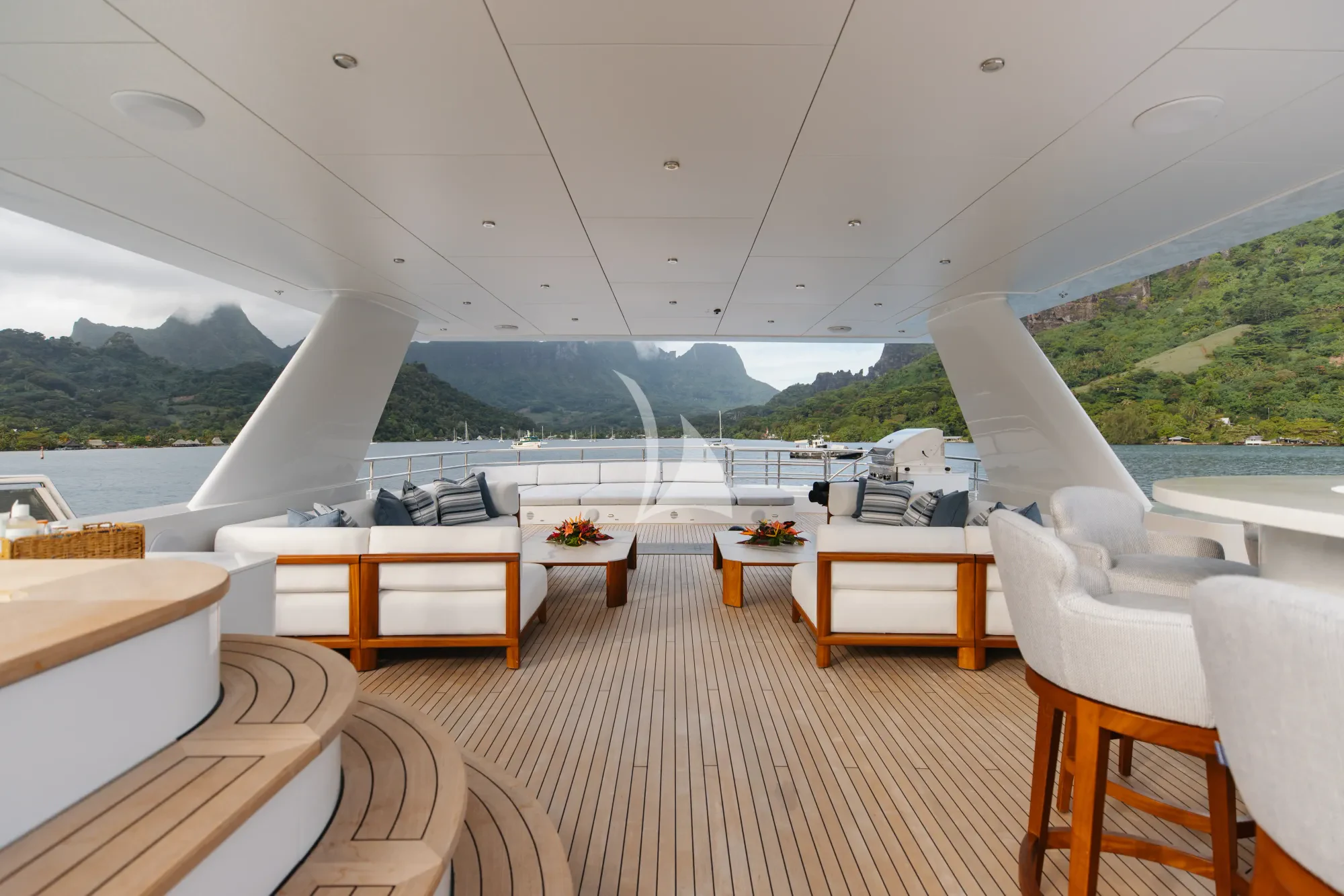 a room with a table chairs and a view of a mountain range aboard LIMITED RISKS Yacht for Charter
