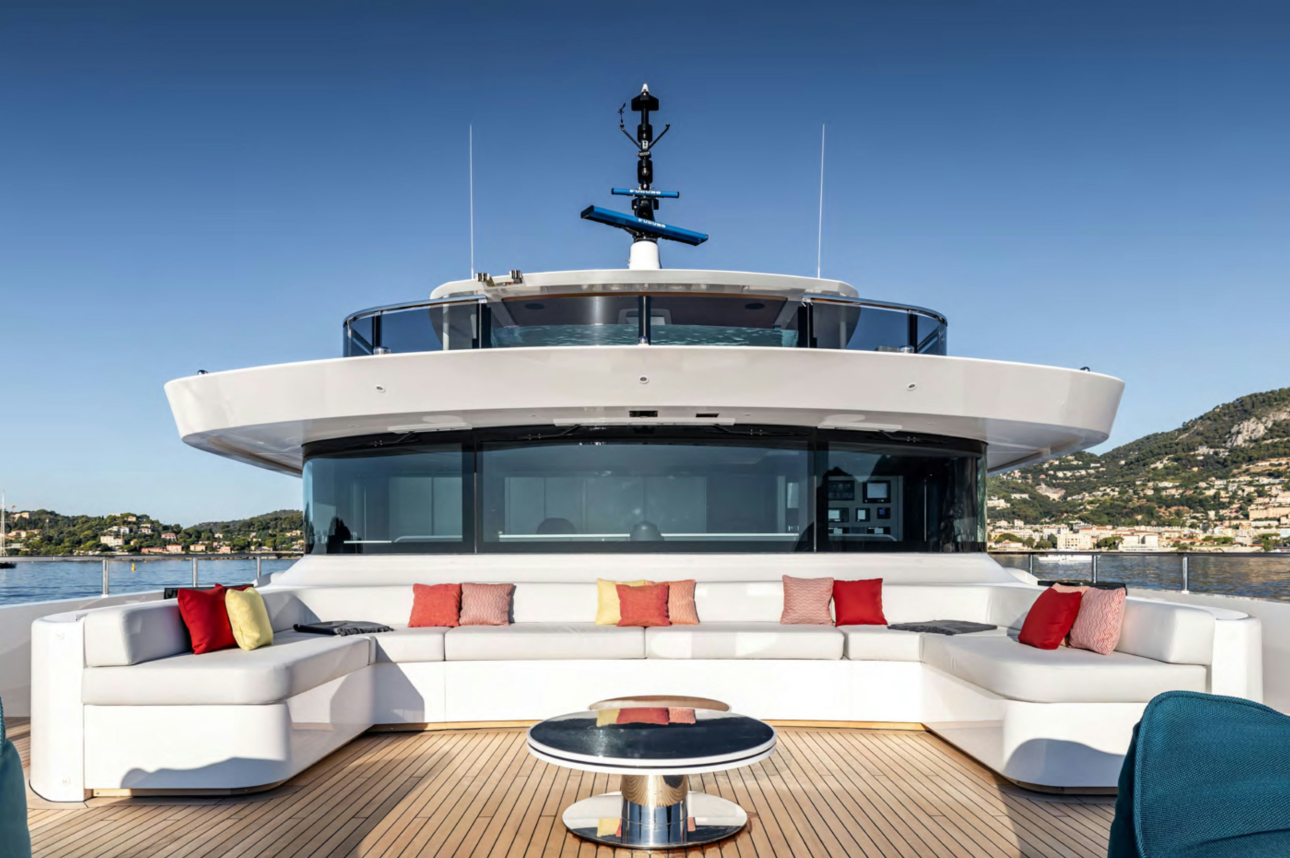 a white house with a white roof and red pillows on a sunny day aboard FELICITA Yacht for Charter