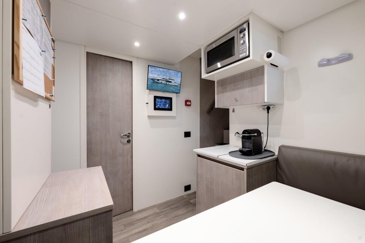 a room with a table and a microwave aboard AMICO Yacht for Sale