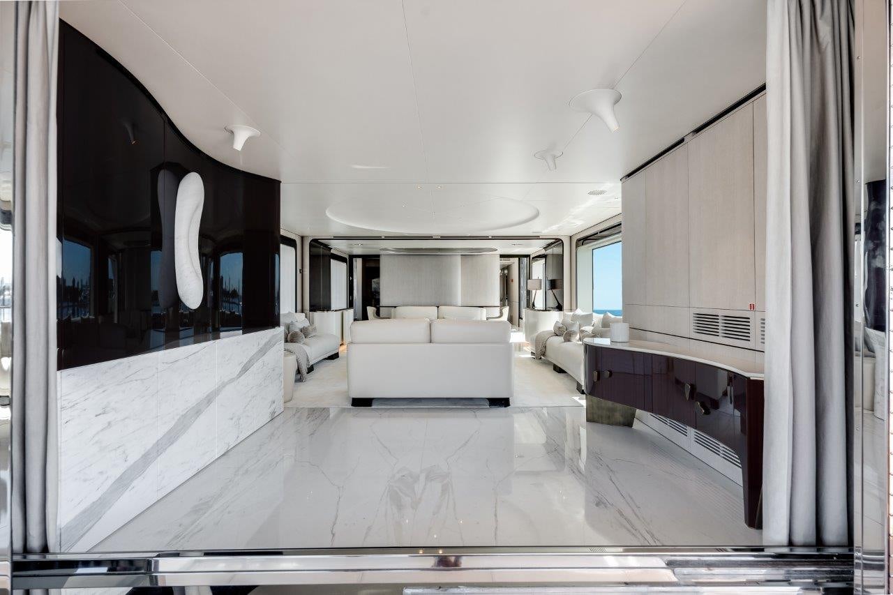 a large living room with white furniture aboard AMICO Yacht for Sale