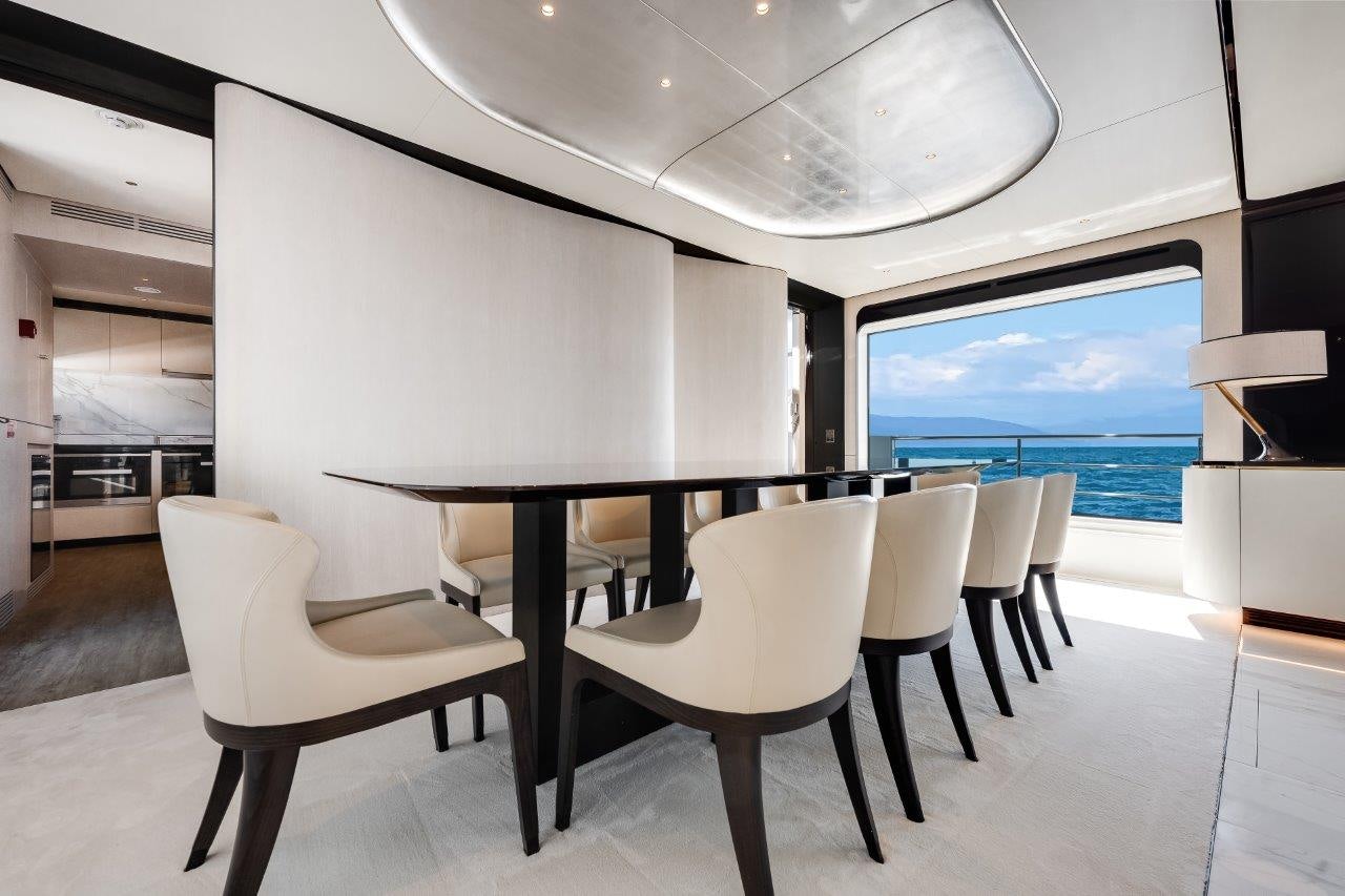a room with a table and chairs aboard AMICO Yacht for Sale