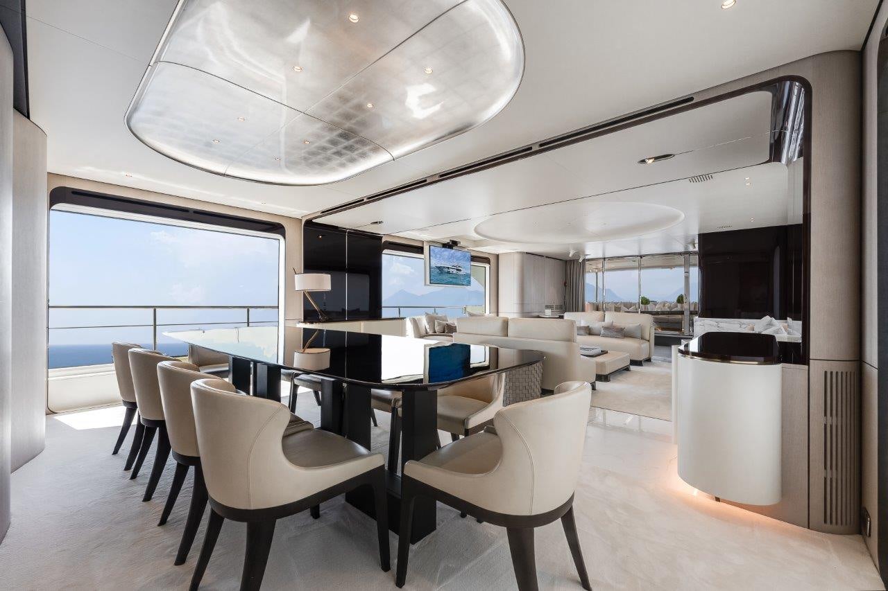 a room with a table and chairs aboard AMICO Yacht for Sale