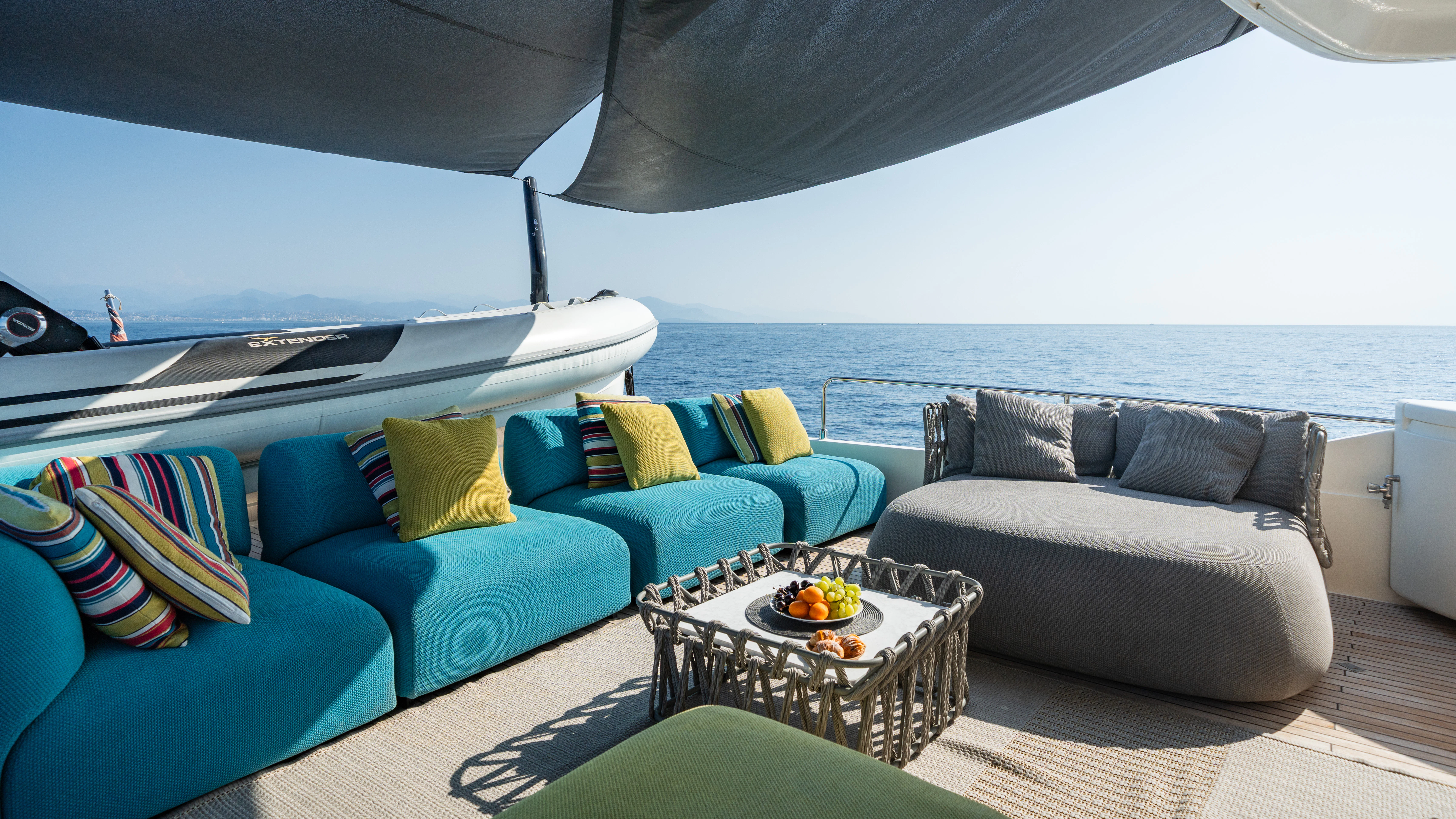 a large blue couch with a white table and a blue couch aboard GIADA Yacht for Sale
