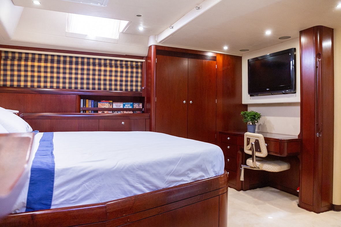 a bedroom with a bed and a television aboard CYGNUS OF ANGLESEY Yacht for Sale