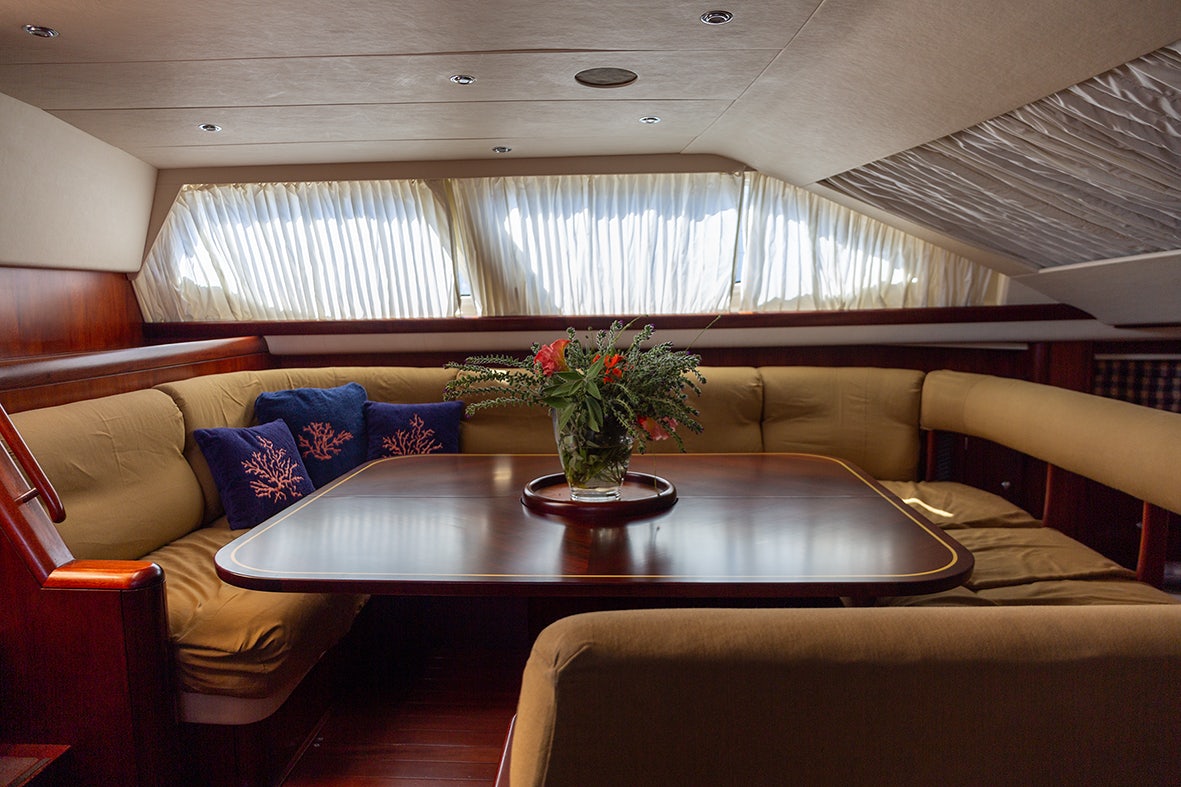 a room with a table and couches aboard CYGNUS OF ANGLESEY Yacht for Sale