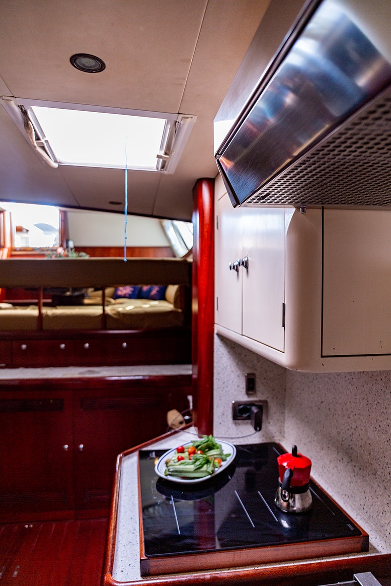 a kitchen with a table and a microwave aboard CYGNUS OF ANGLESEY Yacht for Sale
