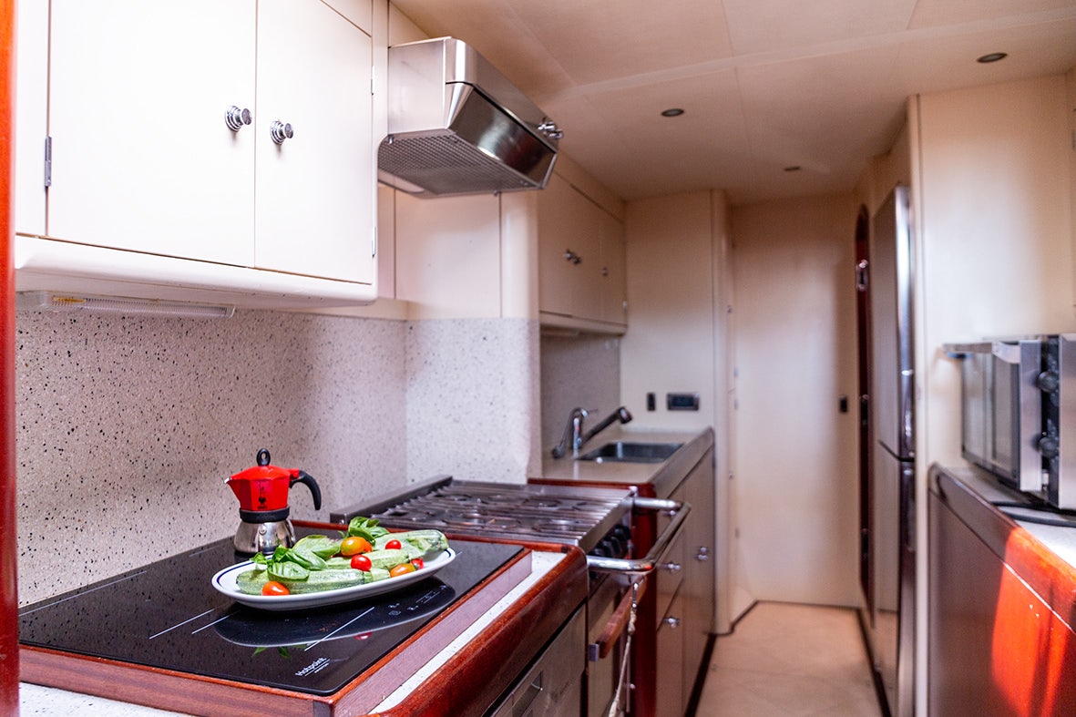 a kitchen with a bowl of fruit on a plate aboard CYGNUS OF ANGLESEY Yacht for Sale