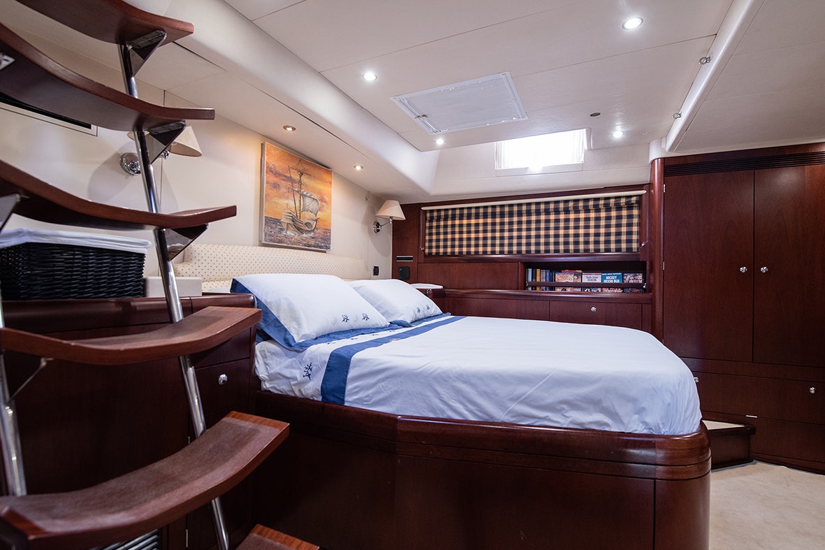 a room with a bed and a desk aboard CYGNUS OF ANGLESEY Yacht for Sale