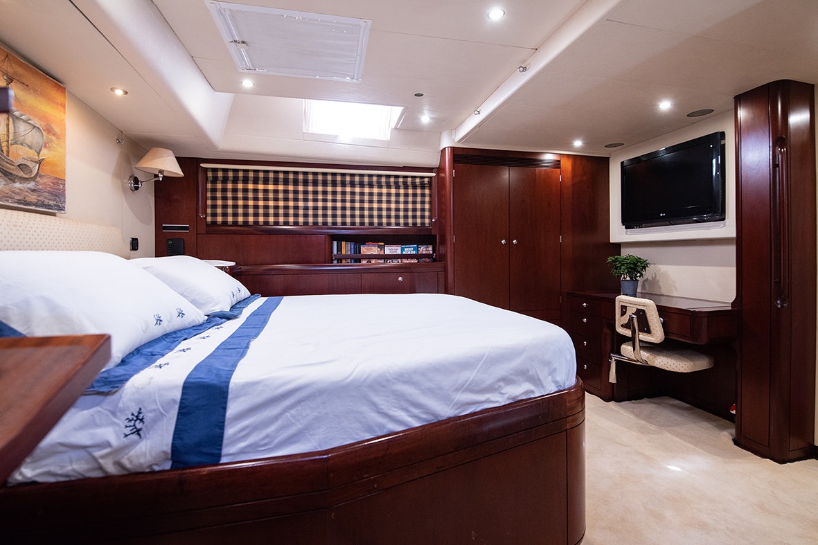 a bedroom with a bed and a television aboard CYGNUS OF ANGLESEY Yacht for Sale