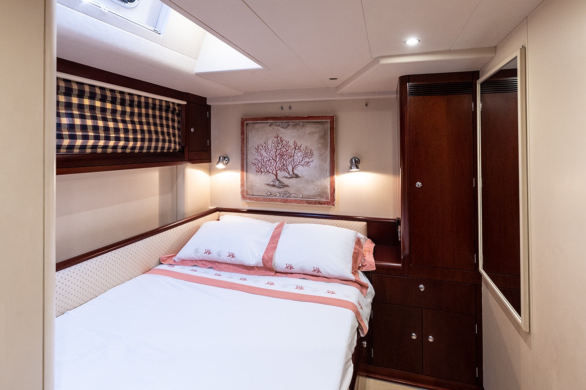 a bedroom with a bed and a painting on the wall aboard CYGNUS OF ANGLESEY Yacht for Sale