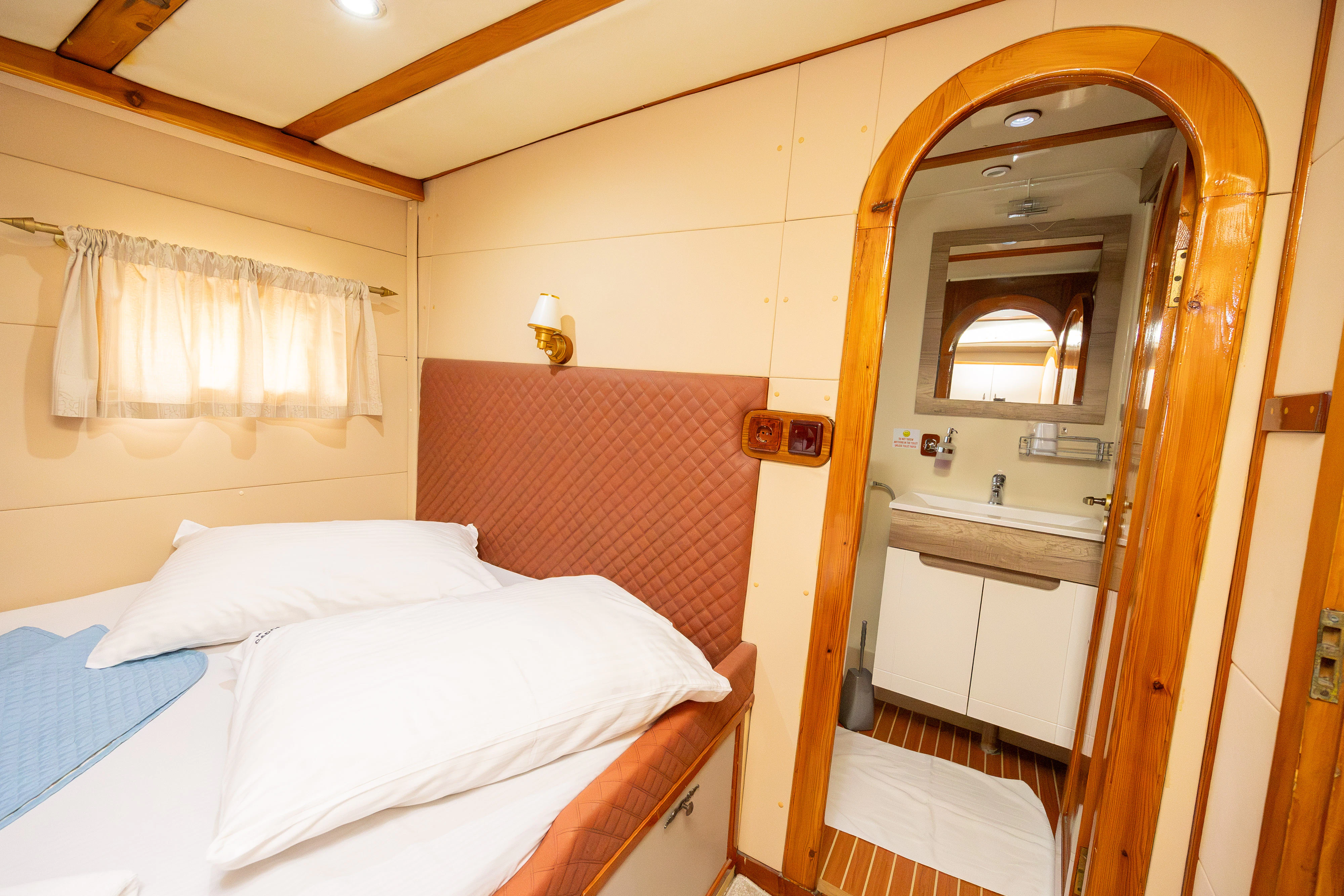 a bedroom with a bed and a mirror aboard GULET GARDELIN Yacht for Charter