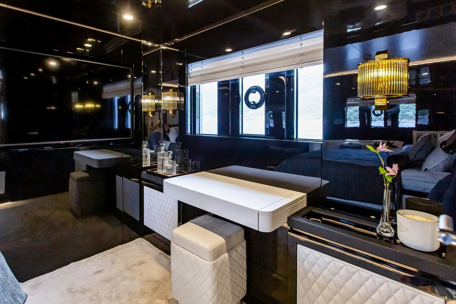 a room with a couch and a table with a vase of flowers aboard LEVANNA Yacht for Sale