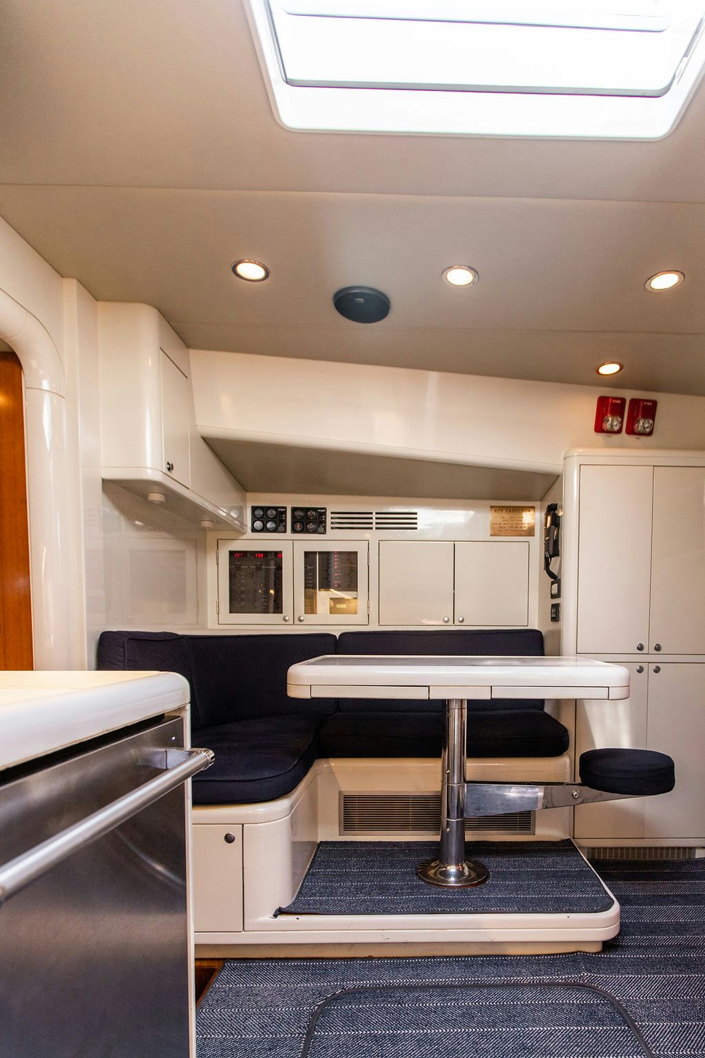 a kitchen with a bar and chairs aboard CABOCHON Yacht for Sale