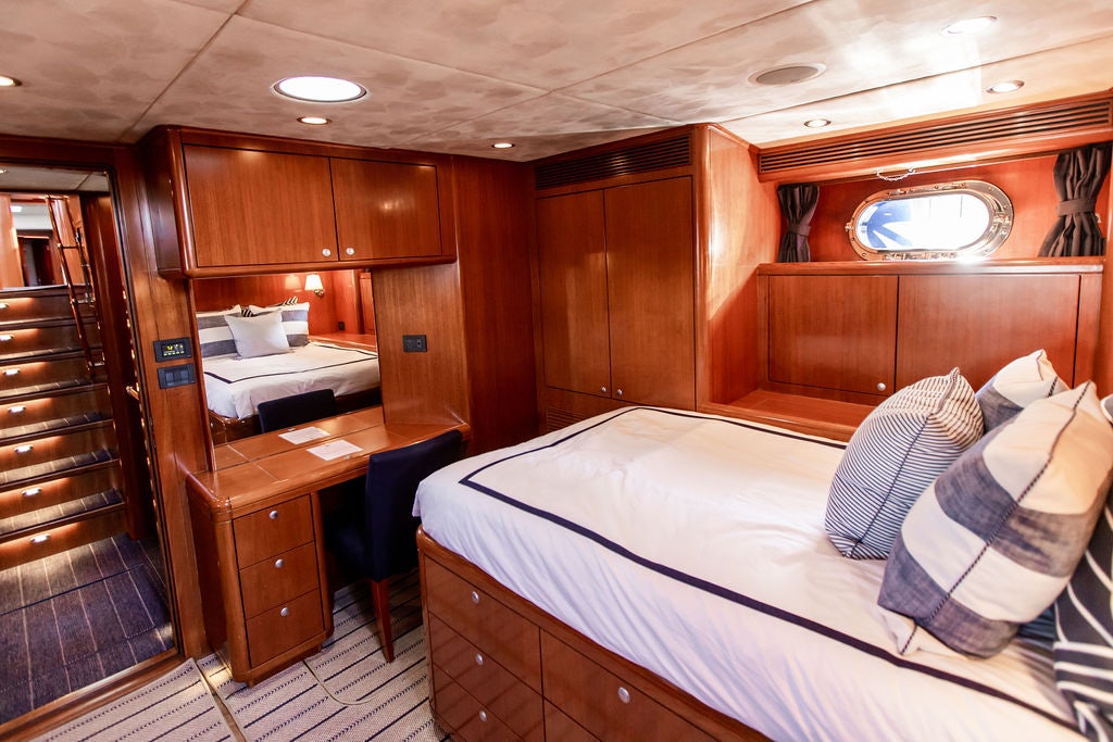 a bedroom with a bed and a wood closet aboard CABOCHON Yacht for Sale