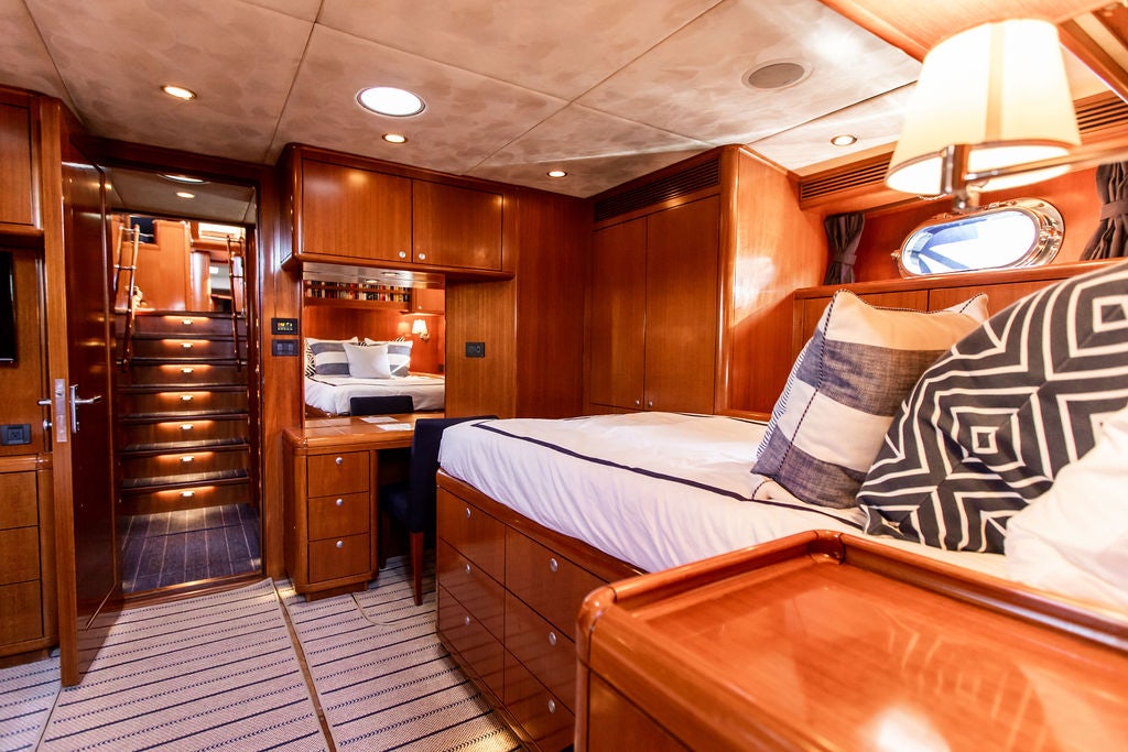 a bedroom with wood cabinets aboard CABOCHON Yacht for Sale