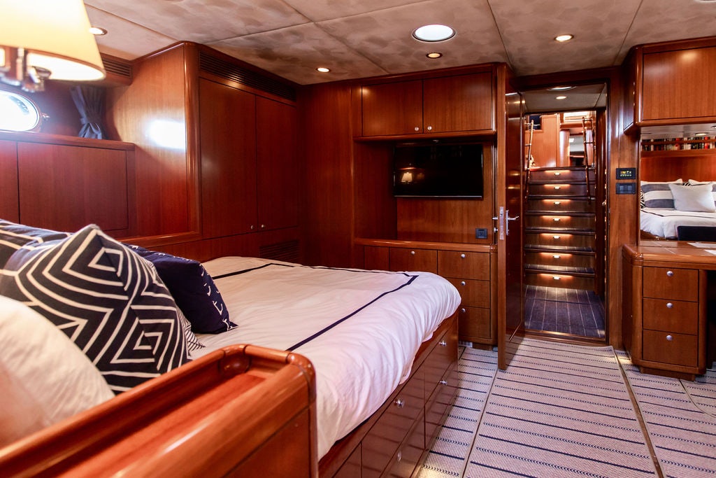 a bedroom with wood cabinets aboard CABOCHON Yacht for Sale