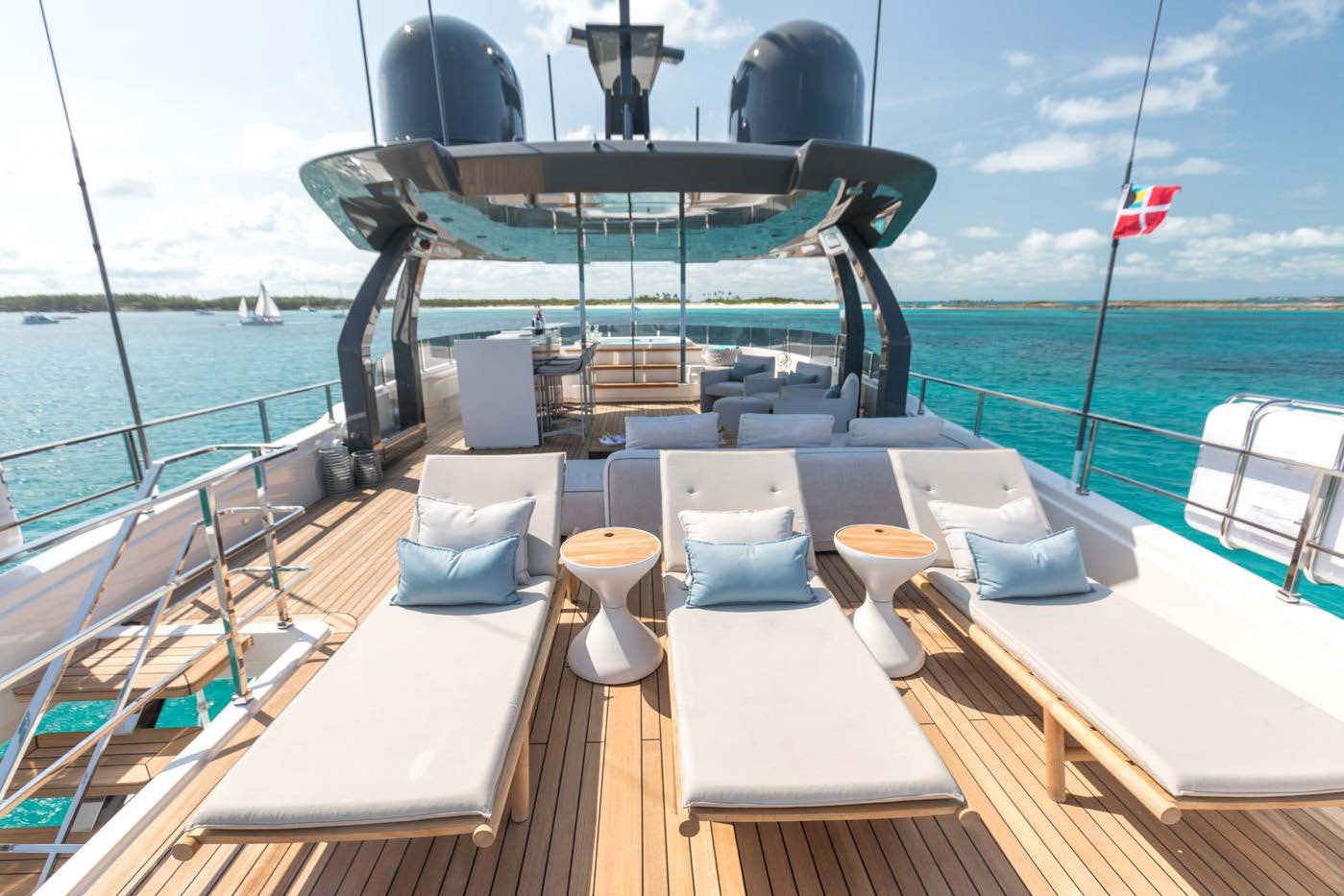 a deck with chairs and tables on it by the water aboard EROS Yacht for Charter