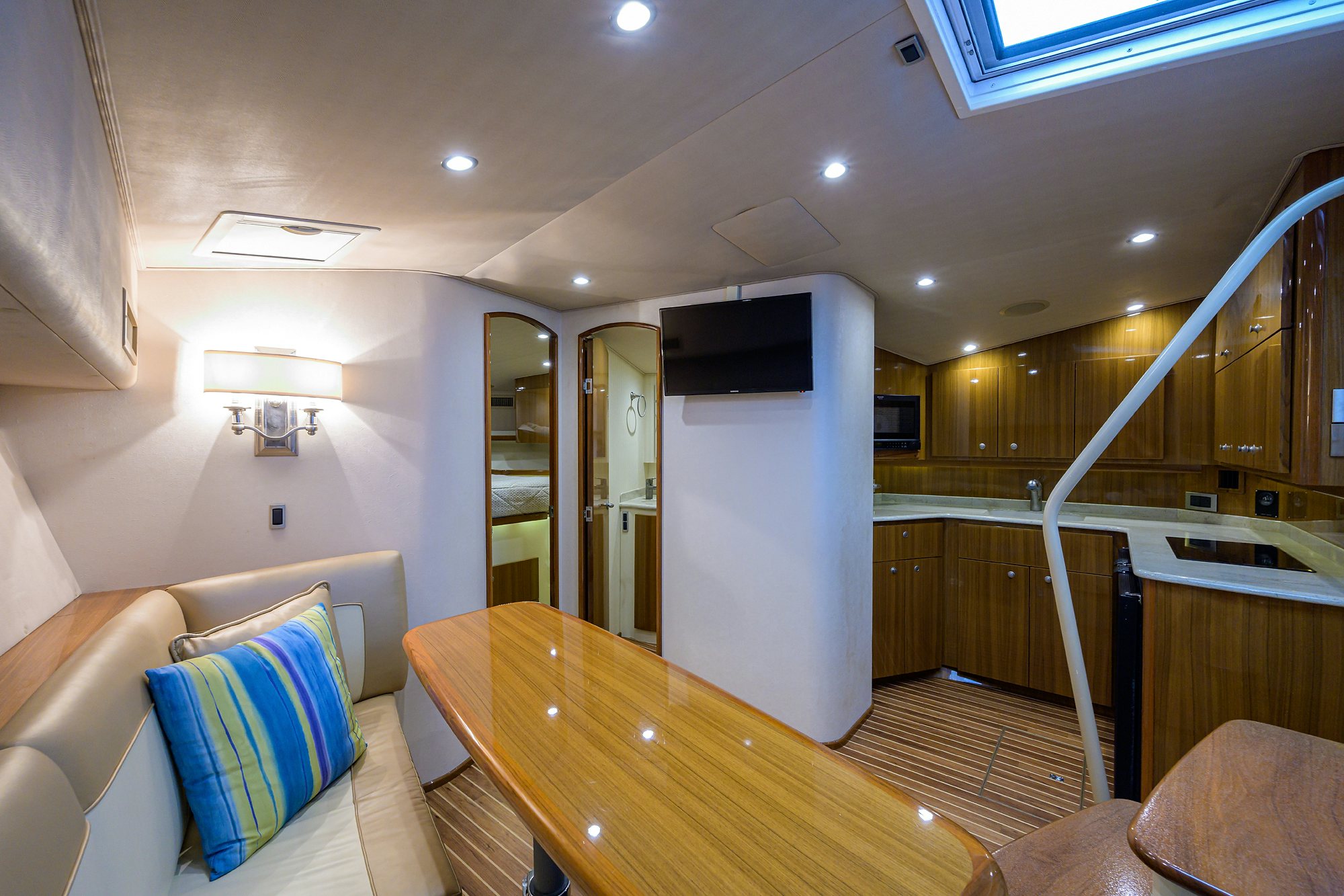 a living room with a wood table and a large mirror aboard GALENE Yacht for Sale