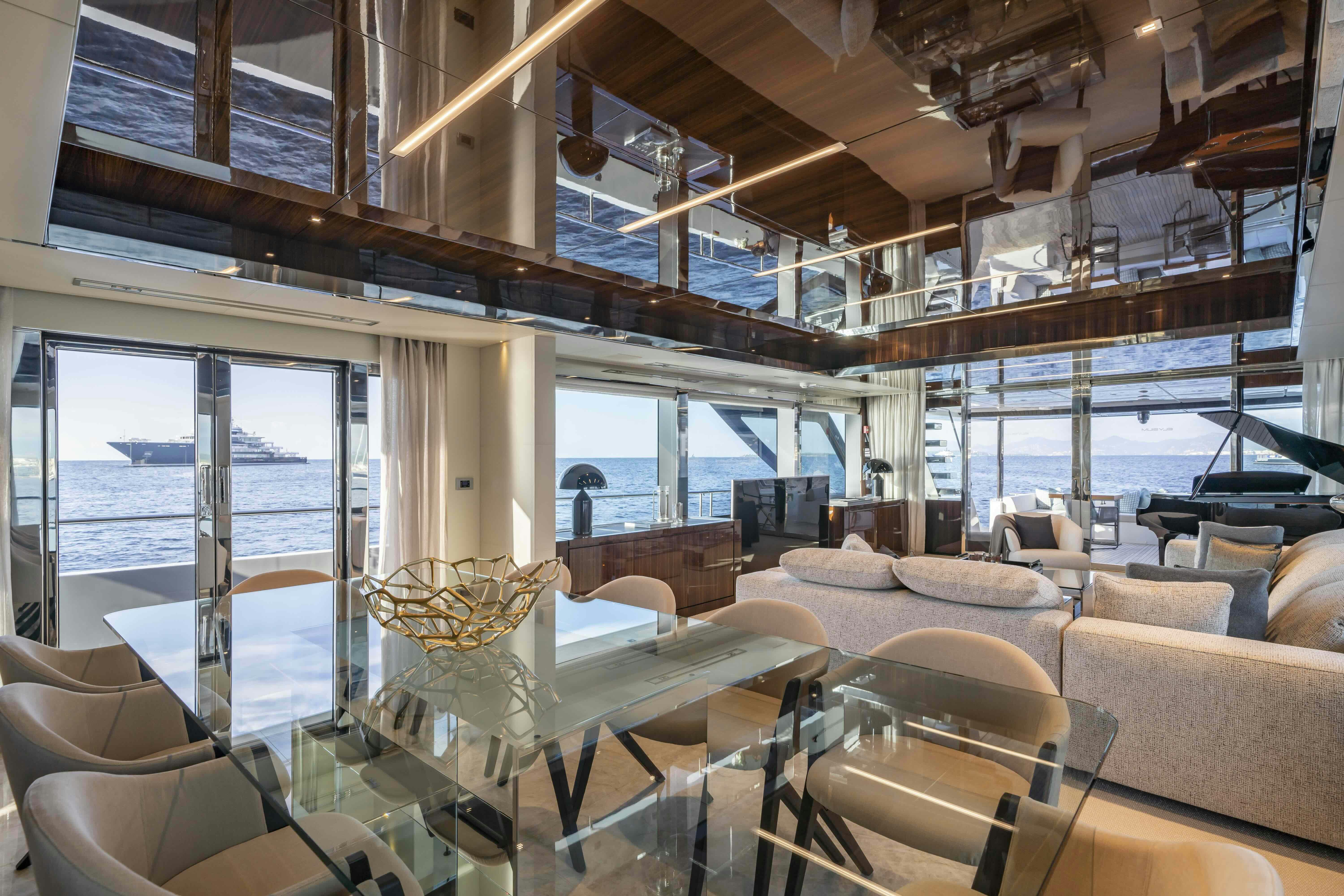 a room with a large window and leather couches aboard ELYSIUM I Yacht for Sale