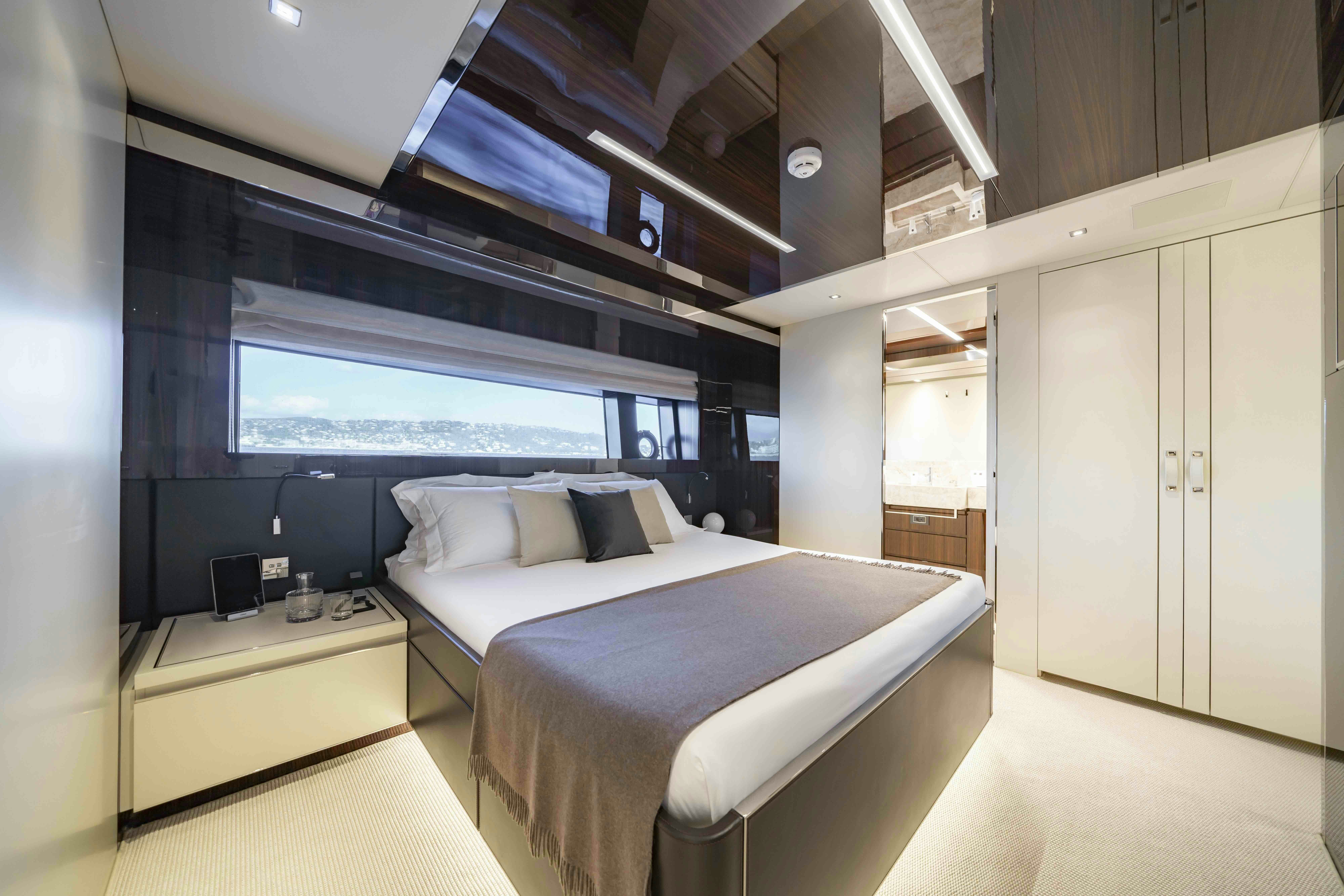 a room with a bed and a large window aboard ELYSIUM I Yacht for Sale