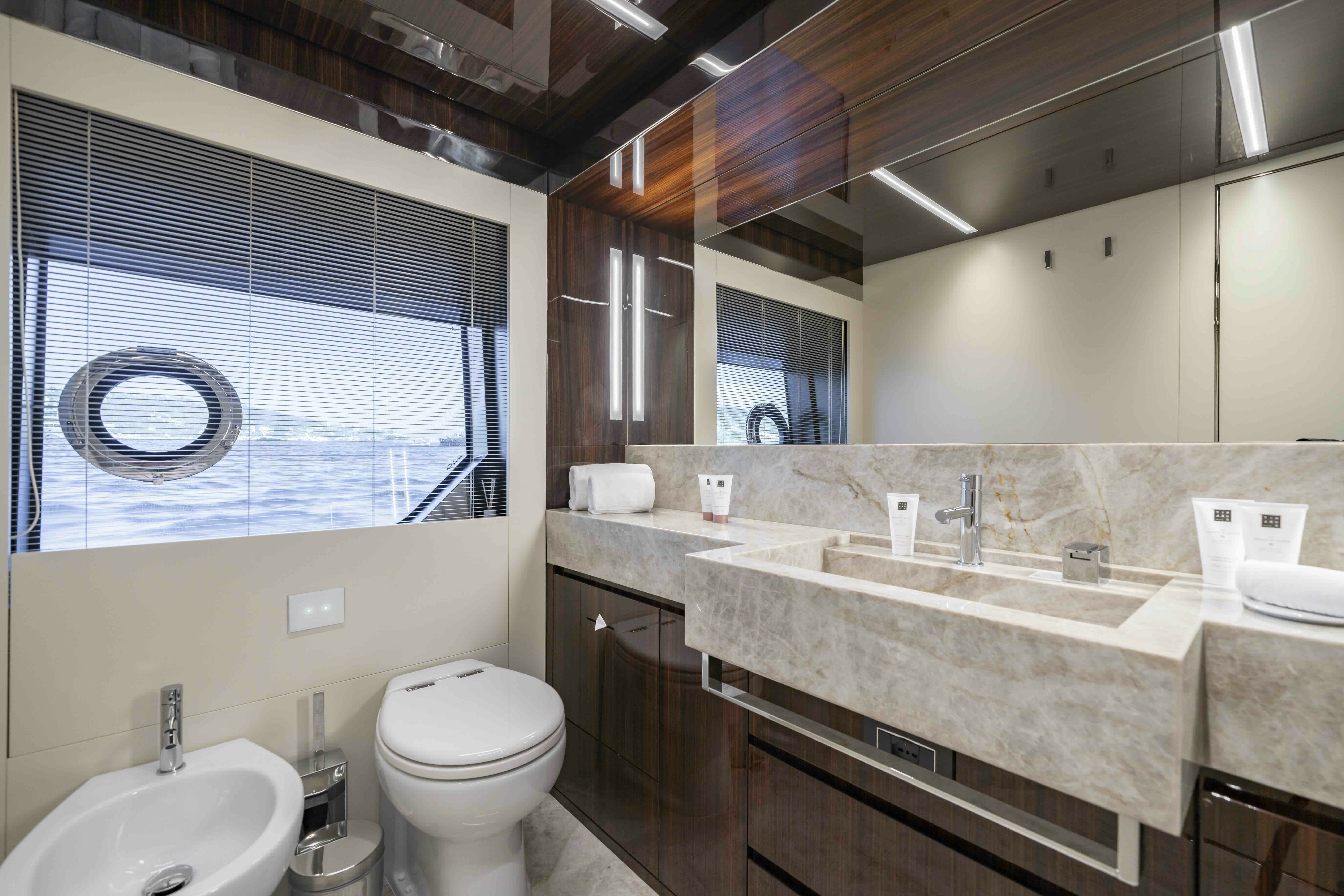 a bathroom with a sink toilet and a window aboard ELYSIUM I Yacht for Sale
