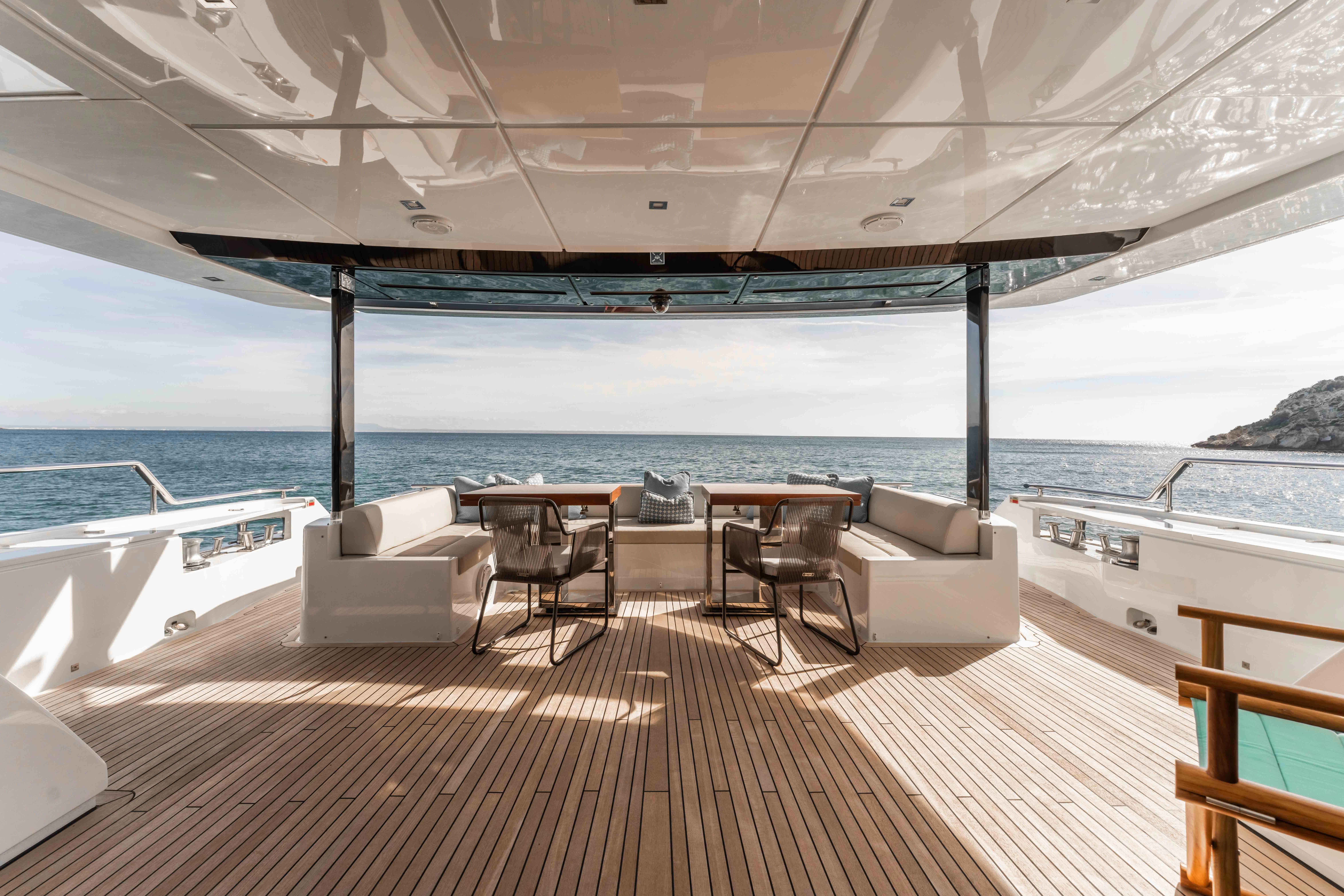 a deck with a view of the ocean and a large boat aboard ELYSIUM I Yacht for Sale
