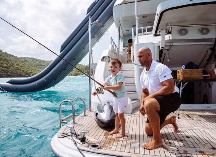 a man and a boy fishing aboard JUST ENOUGH Yacht for Charter