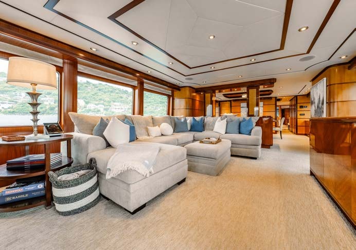 a living room with a large white sofa and a large window aboard JUST ENOUGH Yacht for Charter