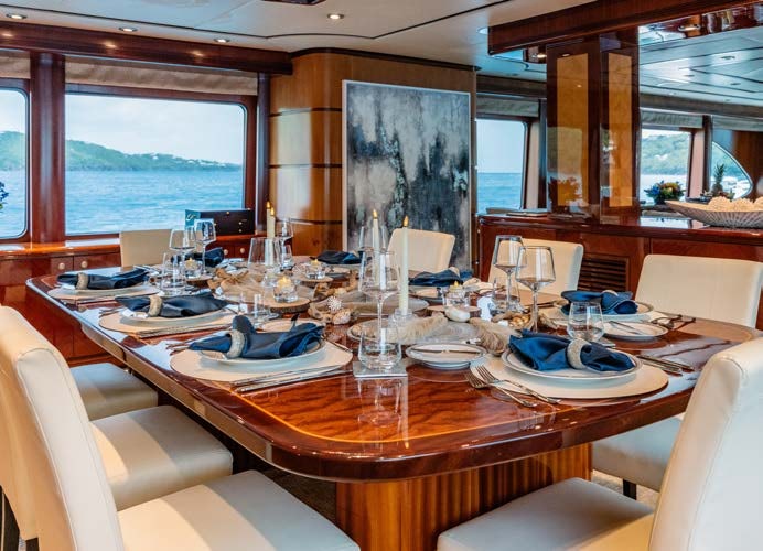 a dining table with plates and glasses aboard JUST ENOUGH Yacht for Charter