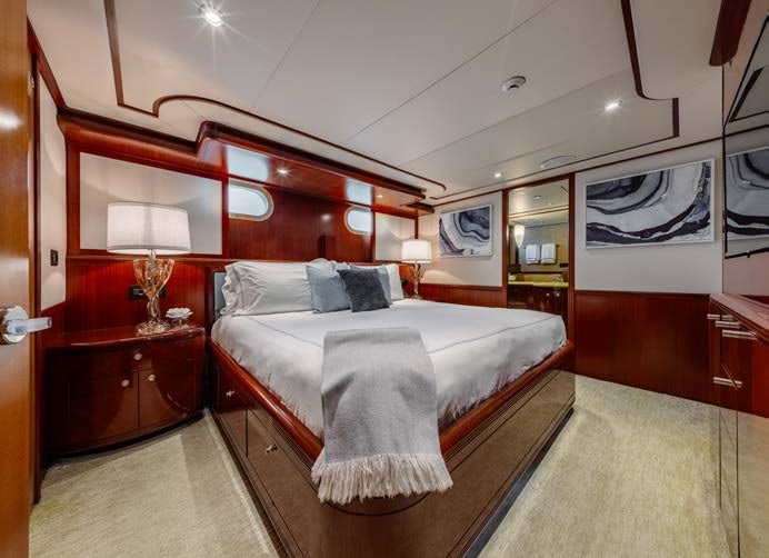 a bedroom with a bed and a mirror aboard JUST ENOUGH Yacht for Charter