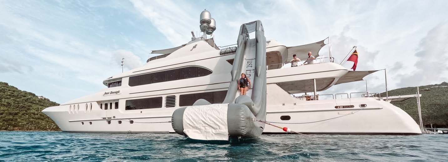 a large white boat with people on it aboard JUST ENOUGH Yacht for Charter