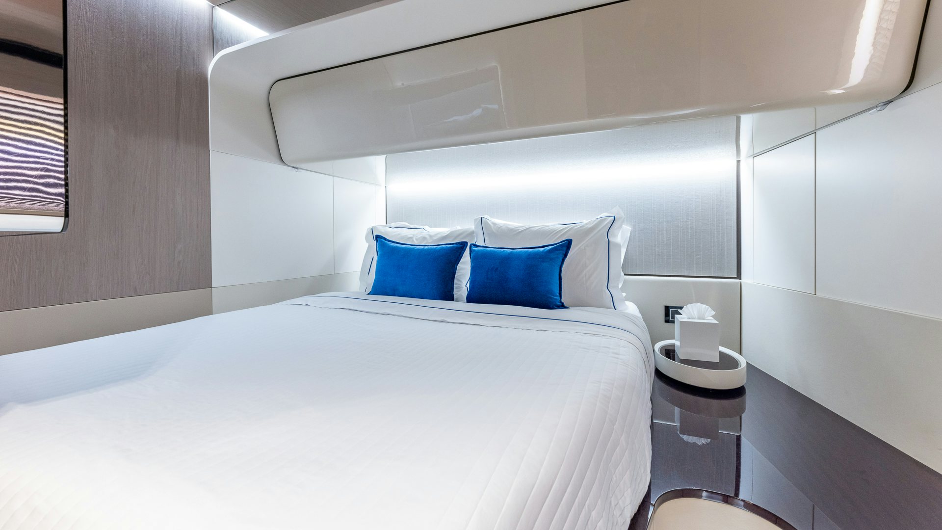 a bed with blue pillows aboard PIER PRESSURE Yacht for Charter