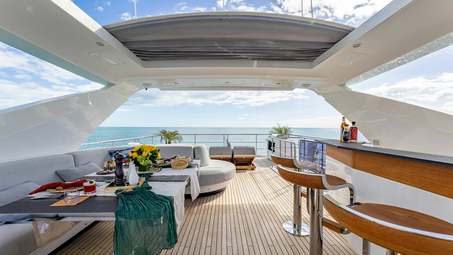 a room with a table chairs and plants with Design Museum in the background aboard PIER PRESSURE Yacht for Charter