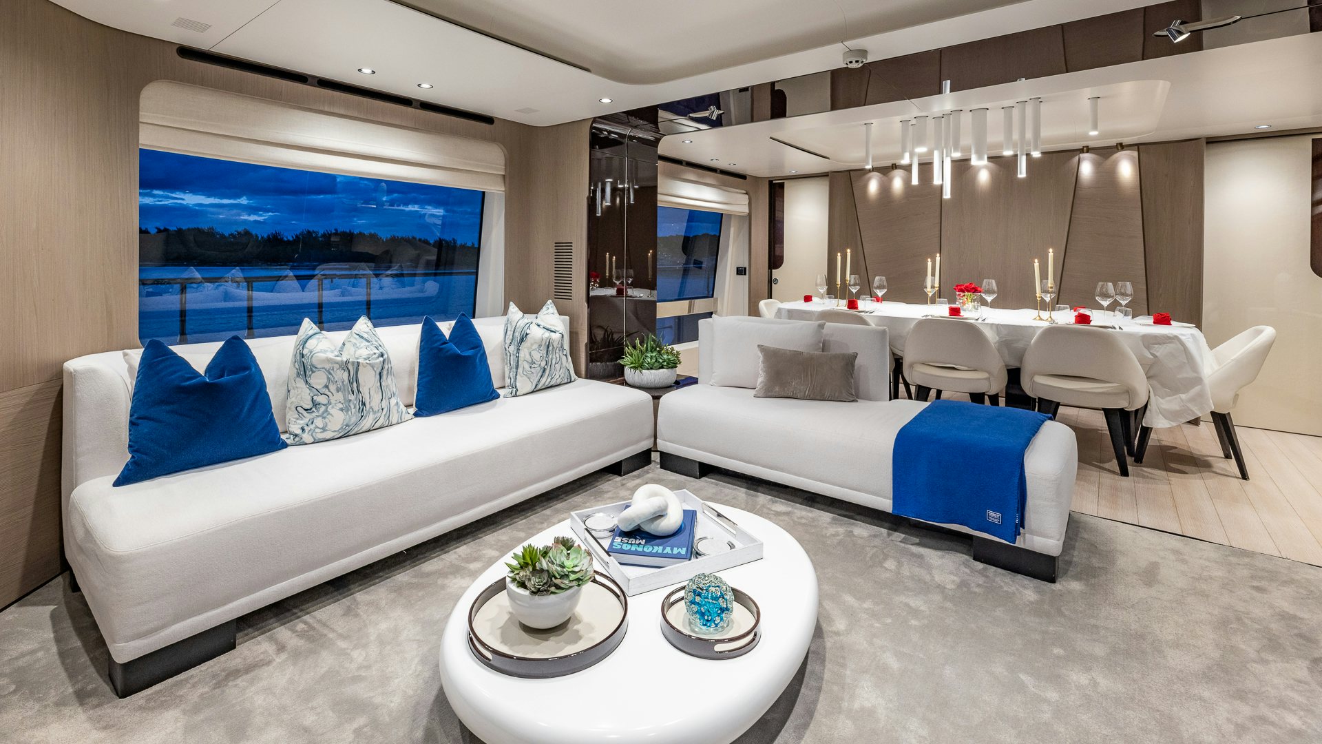 a modern living room with a large white couch and a white table aboard PIER PRESSURE Yacht for Charter