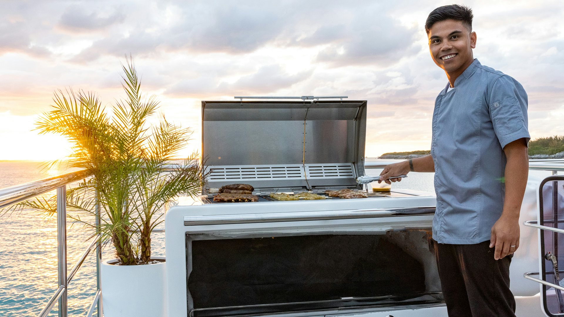 Eddie Paea standing next to a grill aboard PIER PRESSURE Yacht for Charter