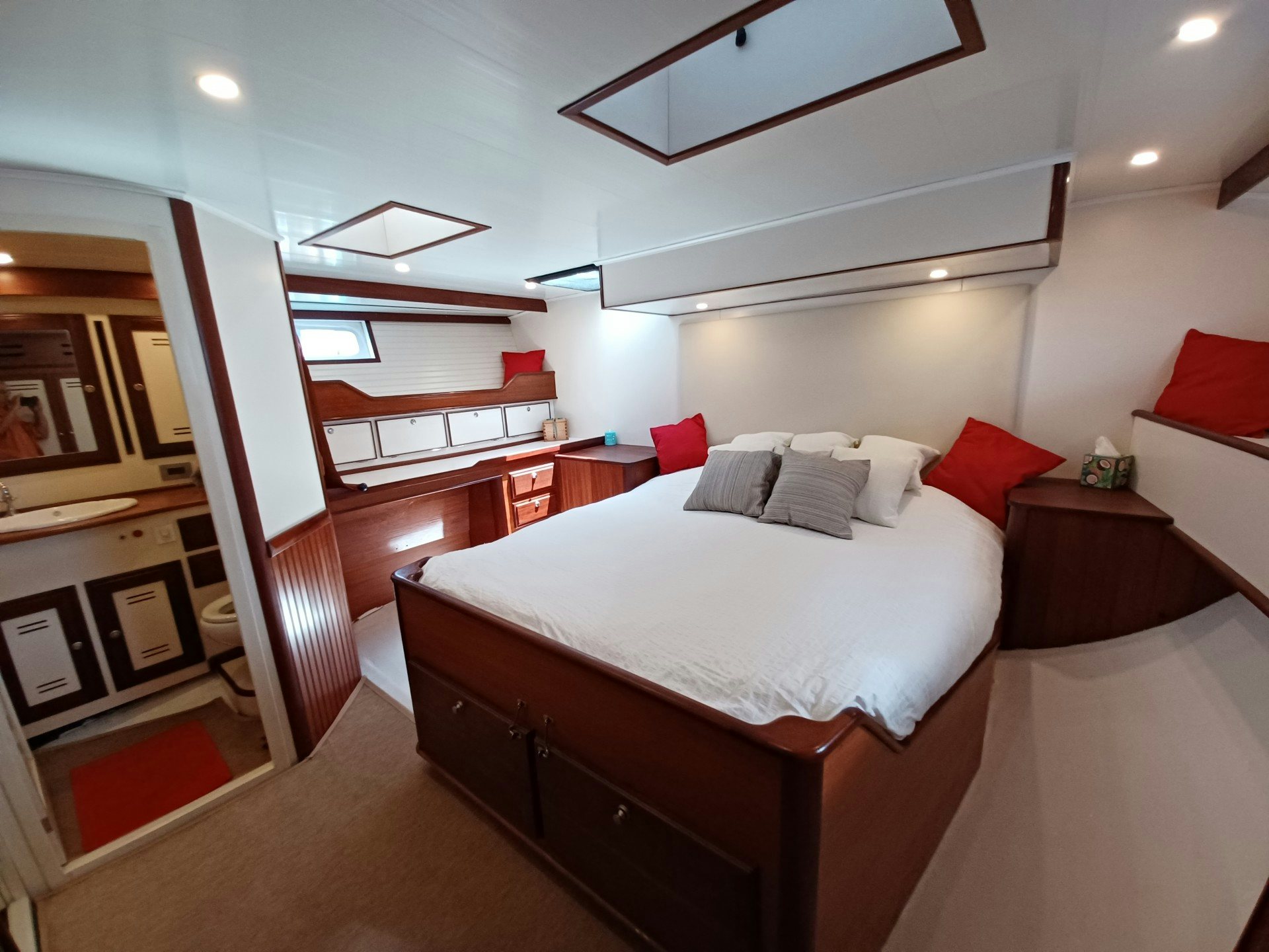 a bedroom with a bed and a mirror aboard TARA Yacht for Sale