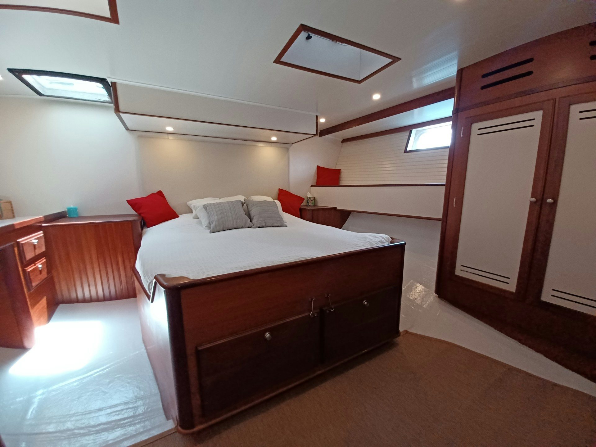 a bedroom with a bed and a closet aboard TARA Yacht for Sale