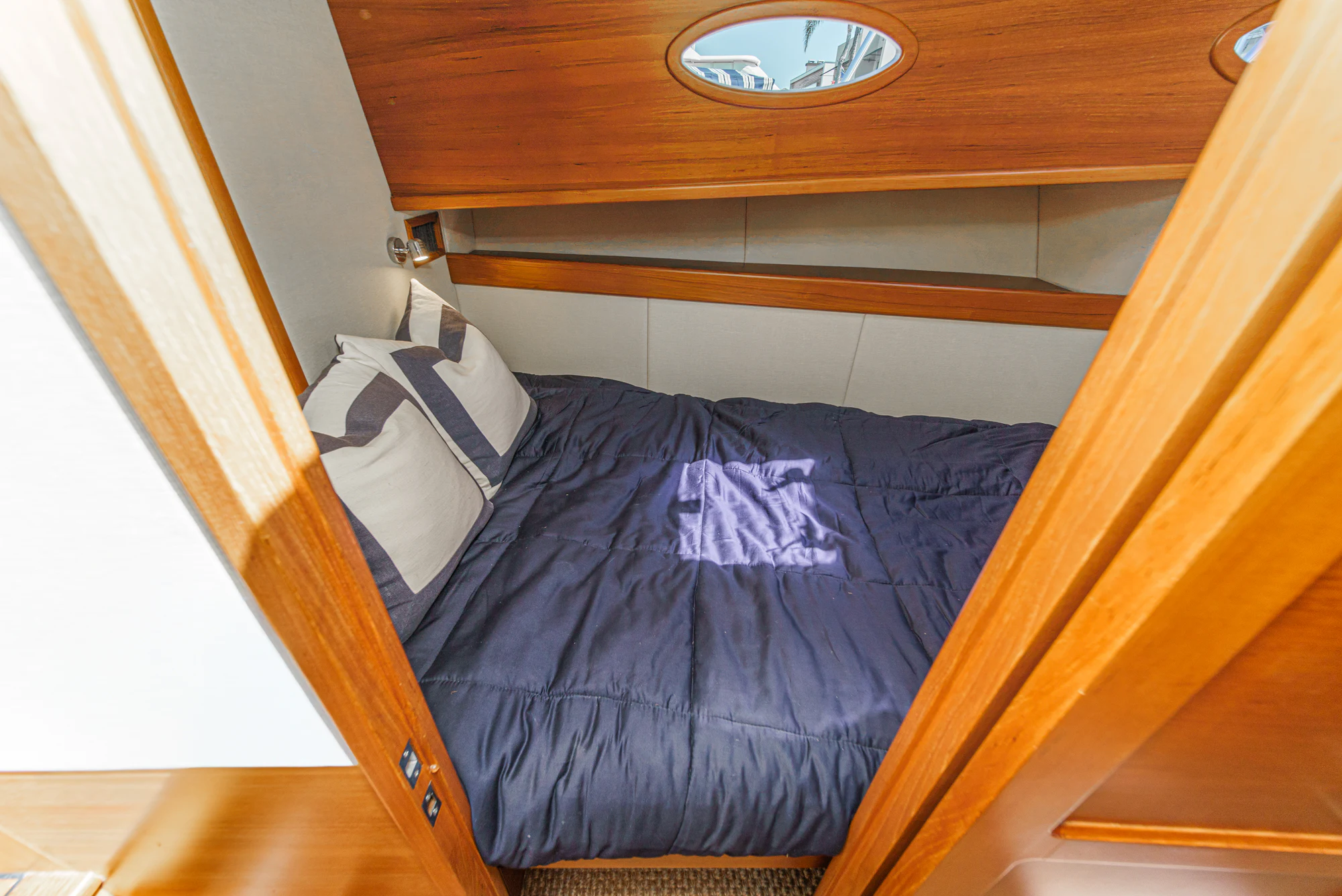 a bed with a blue comforter aboard PIPE DREAM Yacht for Sale