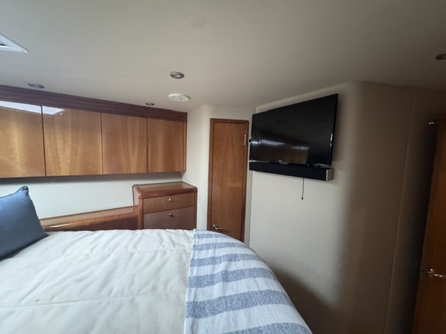 a bedroom with a bed and a television aboard TRUE GRIT Yacht for Sale