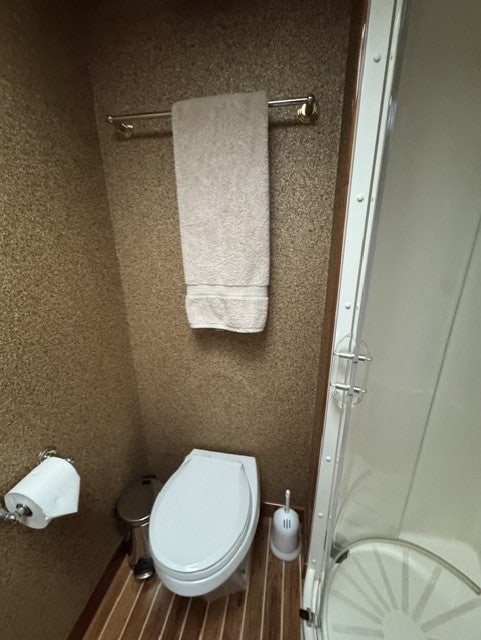 a bathroom with a toilet and towels aboard TRUE GRIT Yacht for Sale