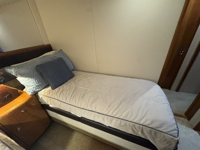 a bed with a white sheet and a wooden headboard aboard TRUE GRIT Yacht for Sale