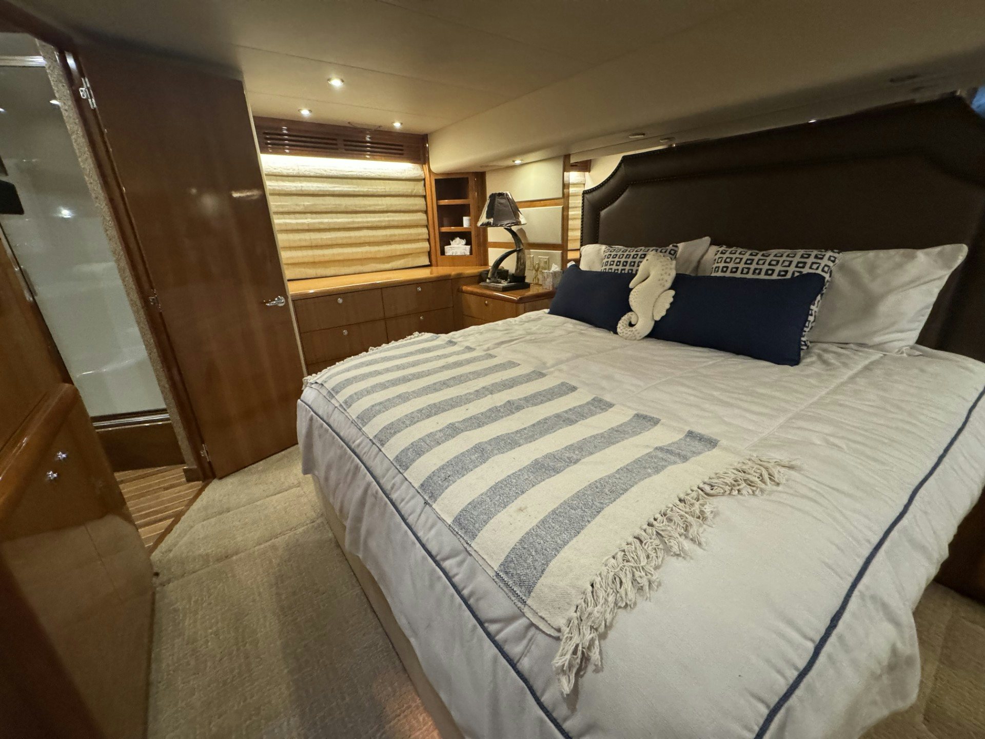 a bed with a white sheet and blue and white pillows aboard TRUE GRIT Yacht for Sale