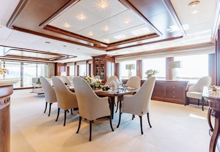 a room with tables and chairs aboard HEMABEJO Yacht for Charter