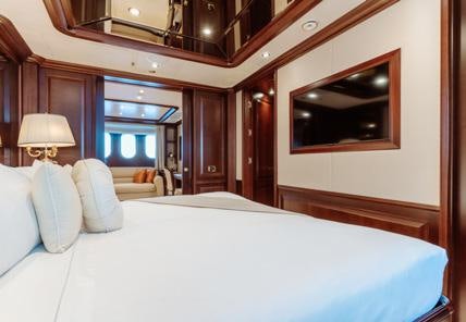 a bed with a mirror above it aboard HEMABEJO Yacht for Charter