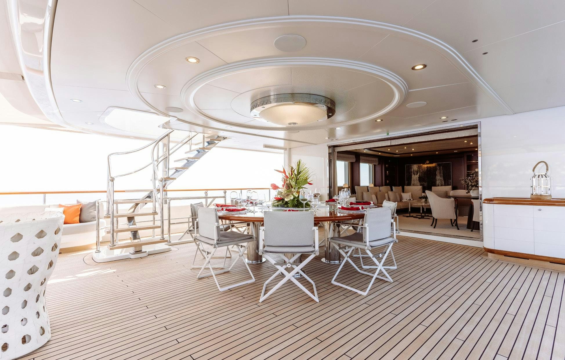 a large white room with tables and chairs aboard HEMABEJO Yacht for Charter